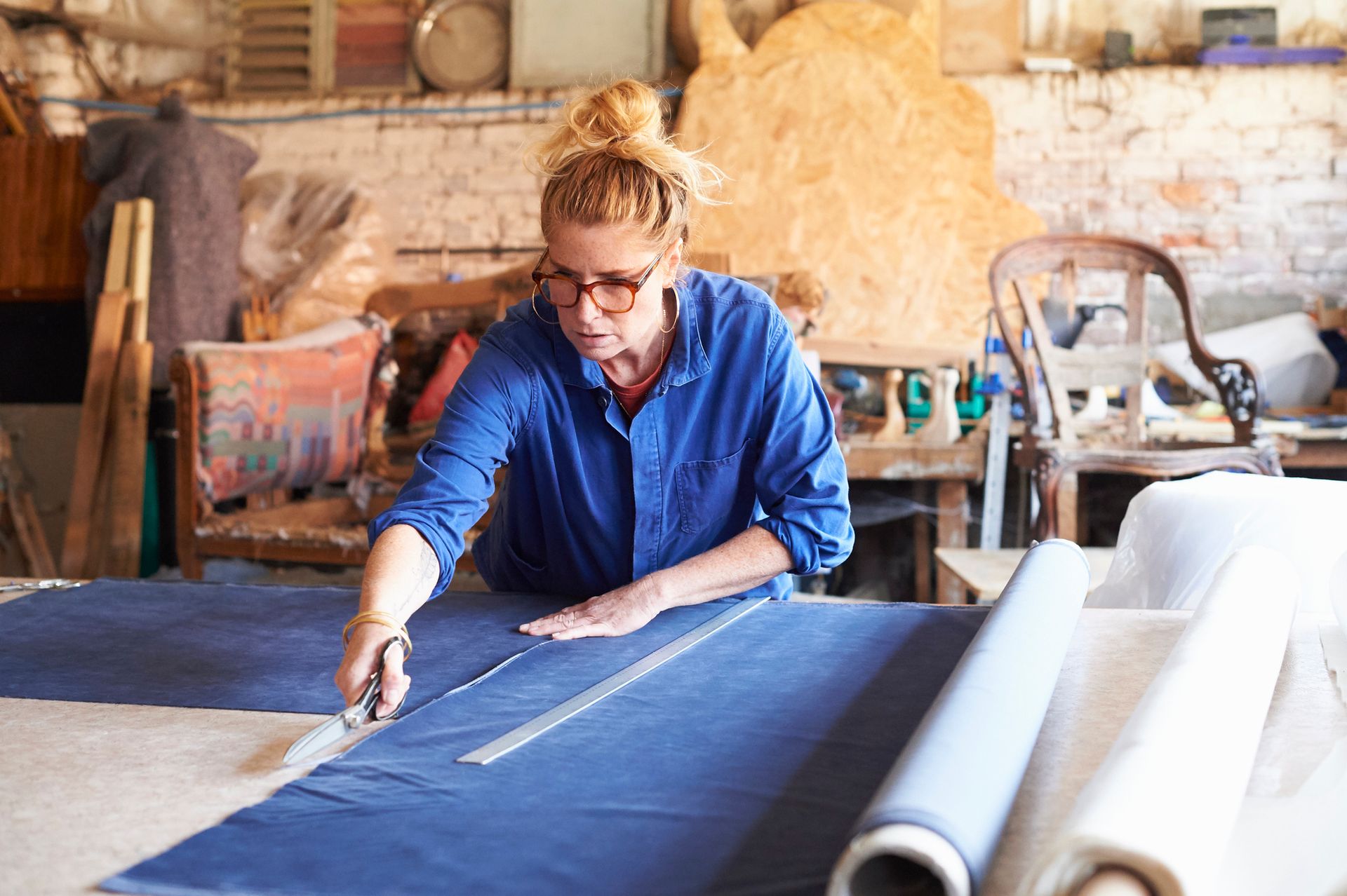 A woman using a knife to cut carpet for a carpet flooring company project.