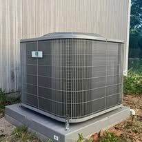 An outdoor air conditioning unit on a concrete base.