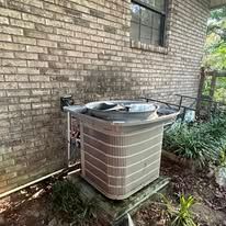 Air conditioning unit next to a brick wall.