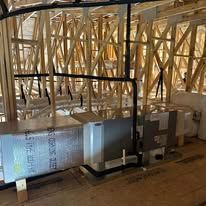 HVAC system installation in unfinished attic space with wooden beams and ductwork.