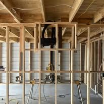 Wooden interior framing with black lift hanging from the ceiling.