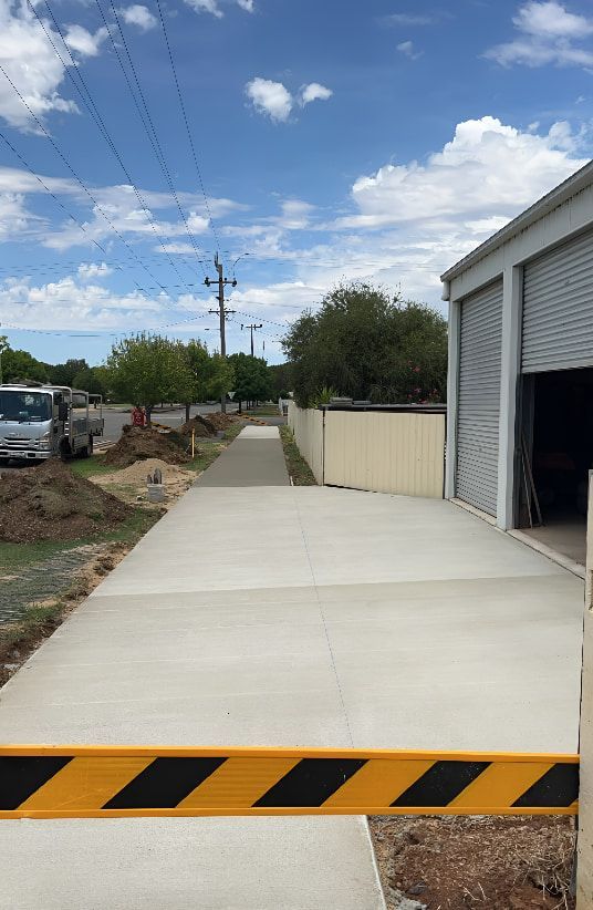 A Concrete Walkway Leading to a Garage — Brycey's Concreting In Frederickton, NSW