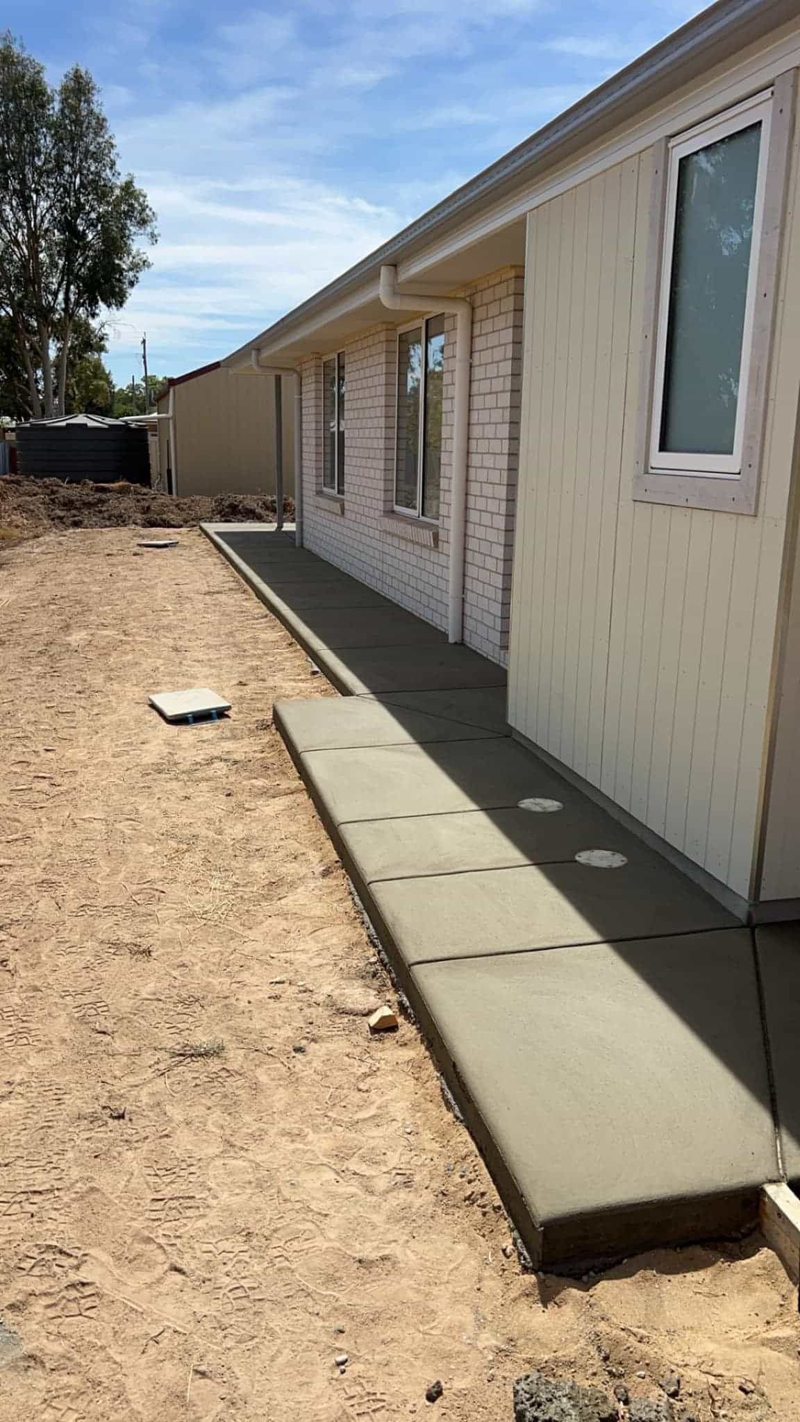 A Concrete Walkway is Being Built in Front of a House — Brycey's Concreting In Frederickton, NSW