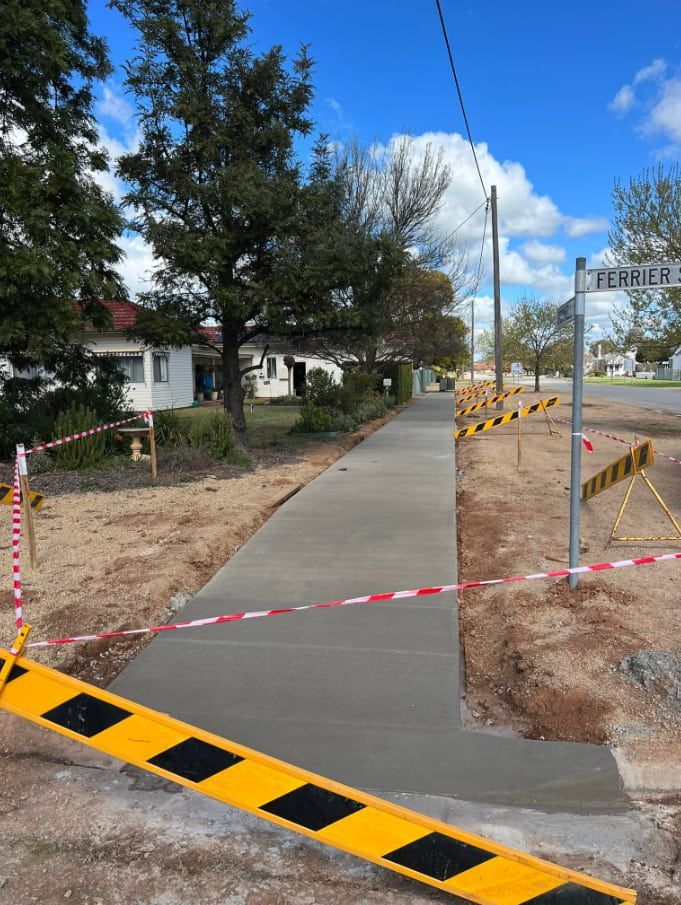 A Concrete Walkway is Being Built Next to a Road — Brycey's Concreting In Frederickton, NSW