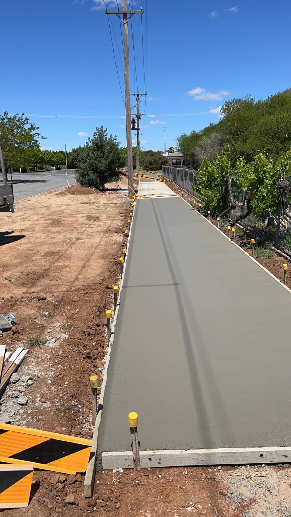 A Concrete Walkway is Being Built Next to a Road — Brycey's Concreting In Frederickton, NSW