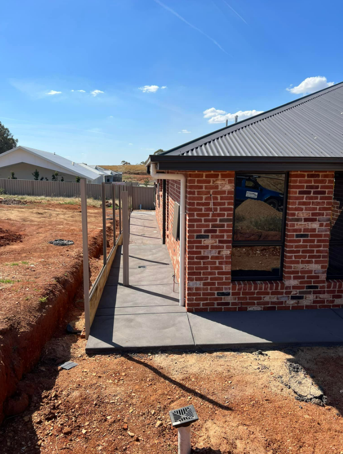 A Brick House With a Walkway Leading to It — Brycey's Concreting In Frederickton, NSW