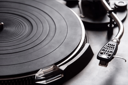 A black and white photo of a modern turntable without a record on it