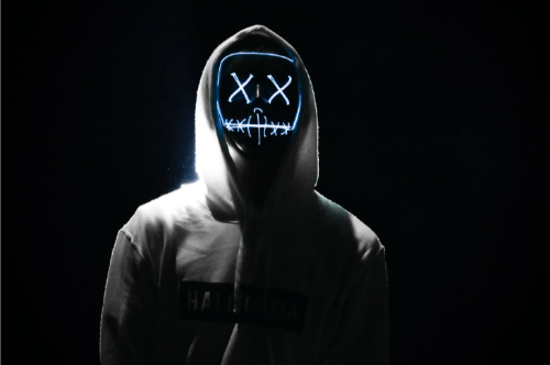 A person wearing a glowing NDM hat in a darkened room