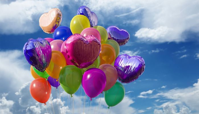 A collection of colorful helium balloons in the sky