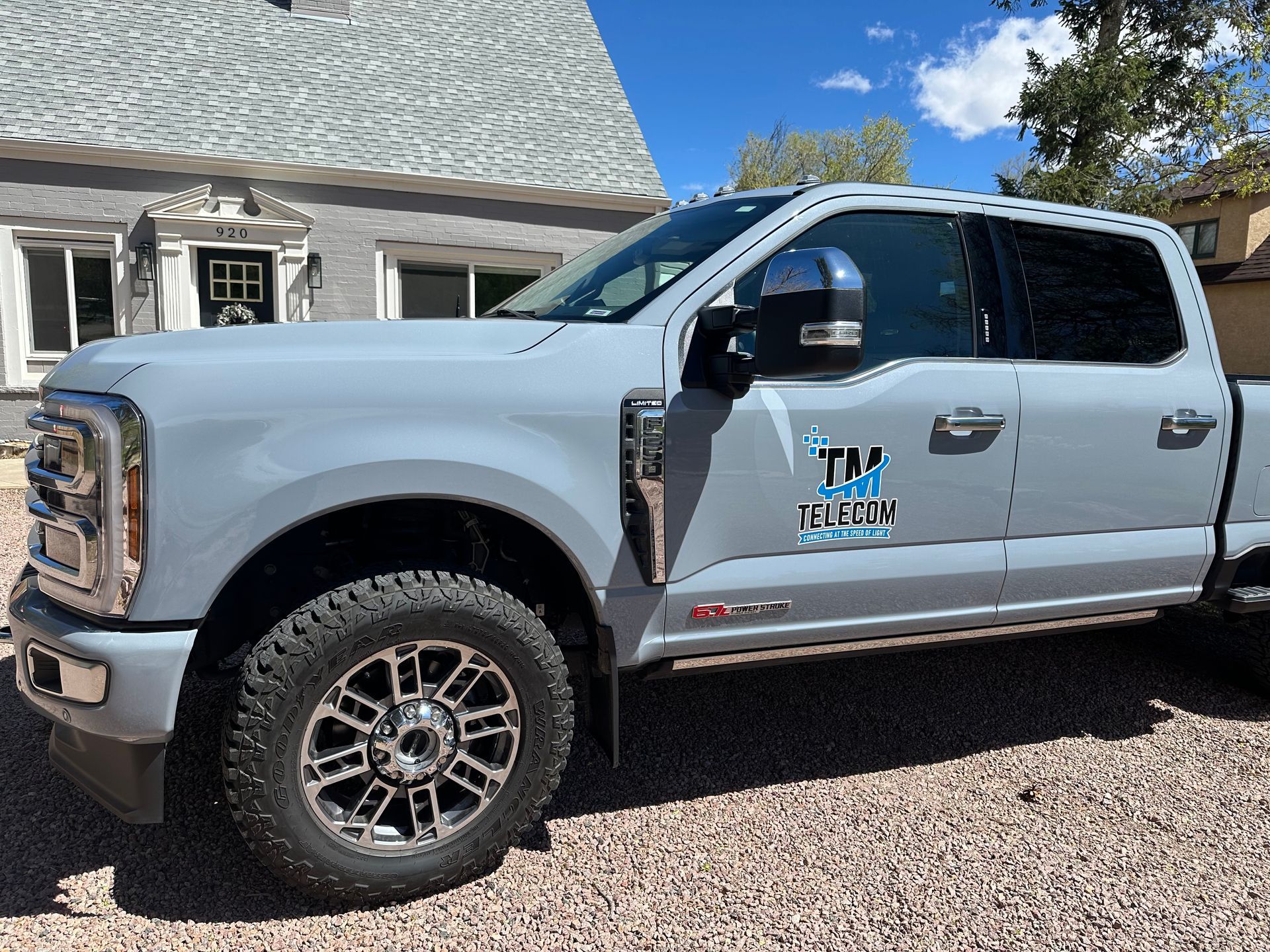 A gray truck is parked in front of a house.