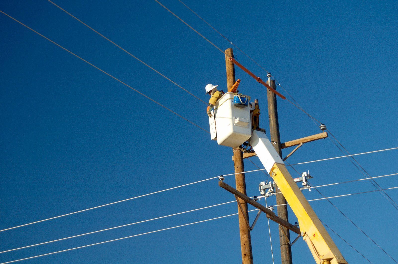 A man in a bucket is working on a power line