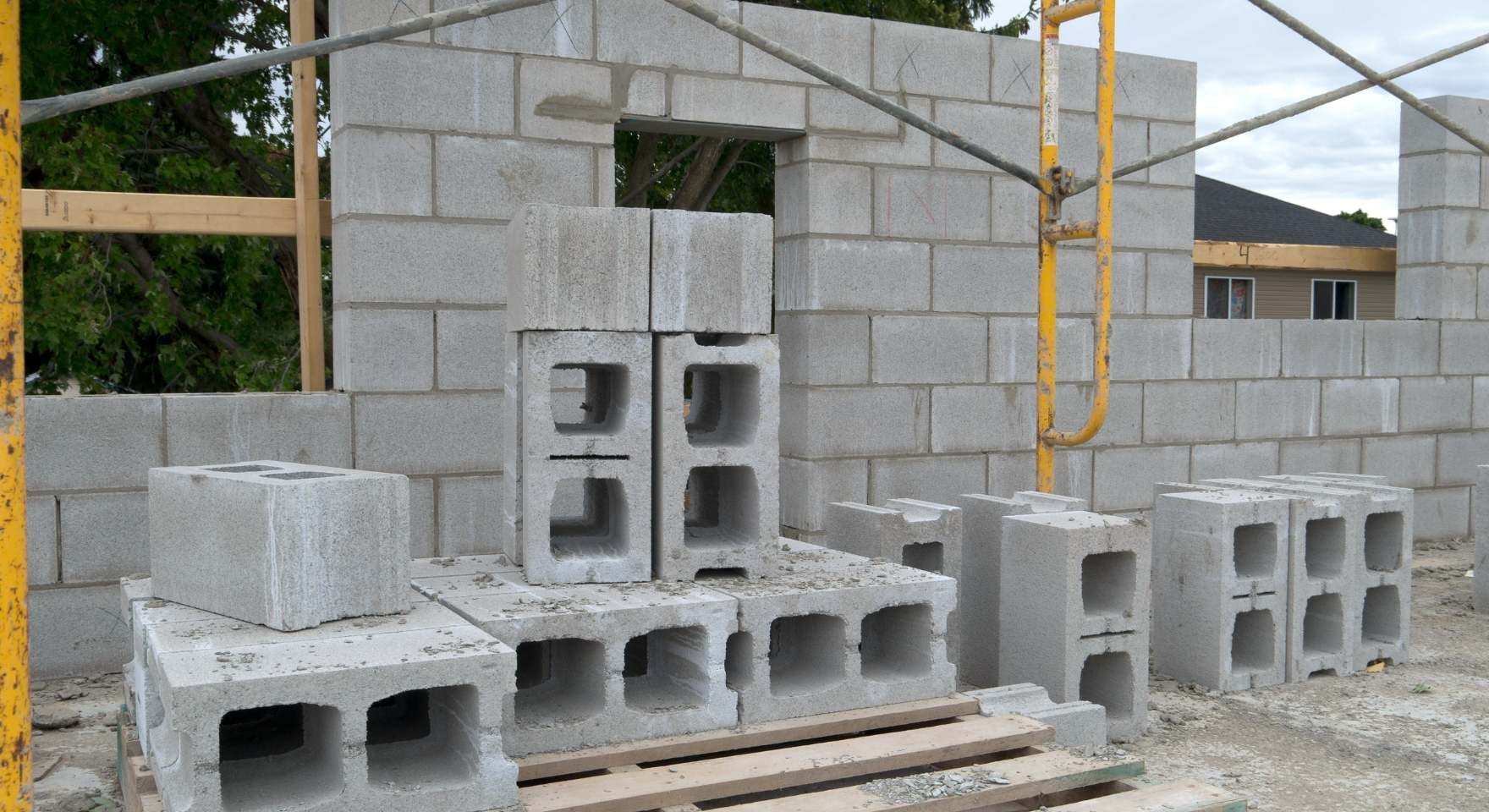 “Concrete block wall being built with stacked cinder blocks and construction materials nearby during a block and retaining wall service in Santa Ana, CA”