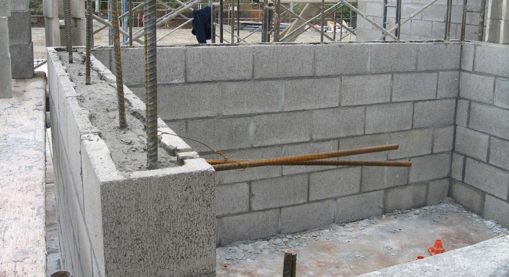 “Partially completed concrete block retaining walls with rebar and construction layout lines during a block and retaining wall service in Santa Ana, CA”