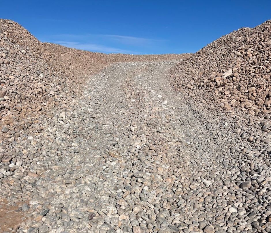 A person is standing in front of a pile of rocks.