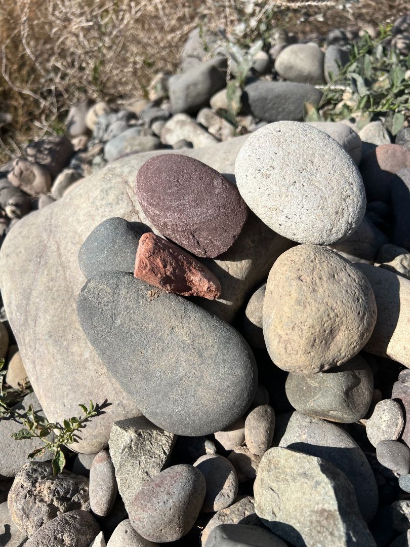 A pile of rocks sitting on top of each other on the ground.