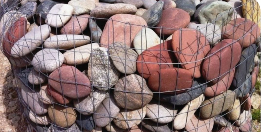 A pile of rocks sitting on top of a wire fence.