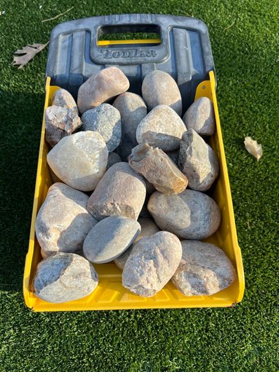 A pile of rocks sitting on top of a gravel road.