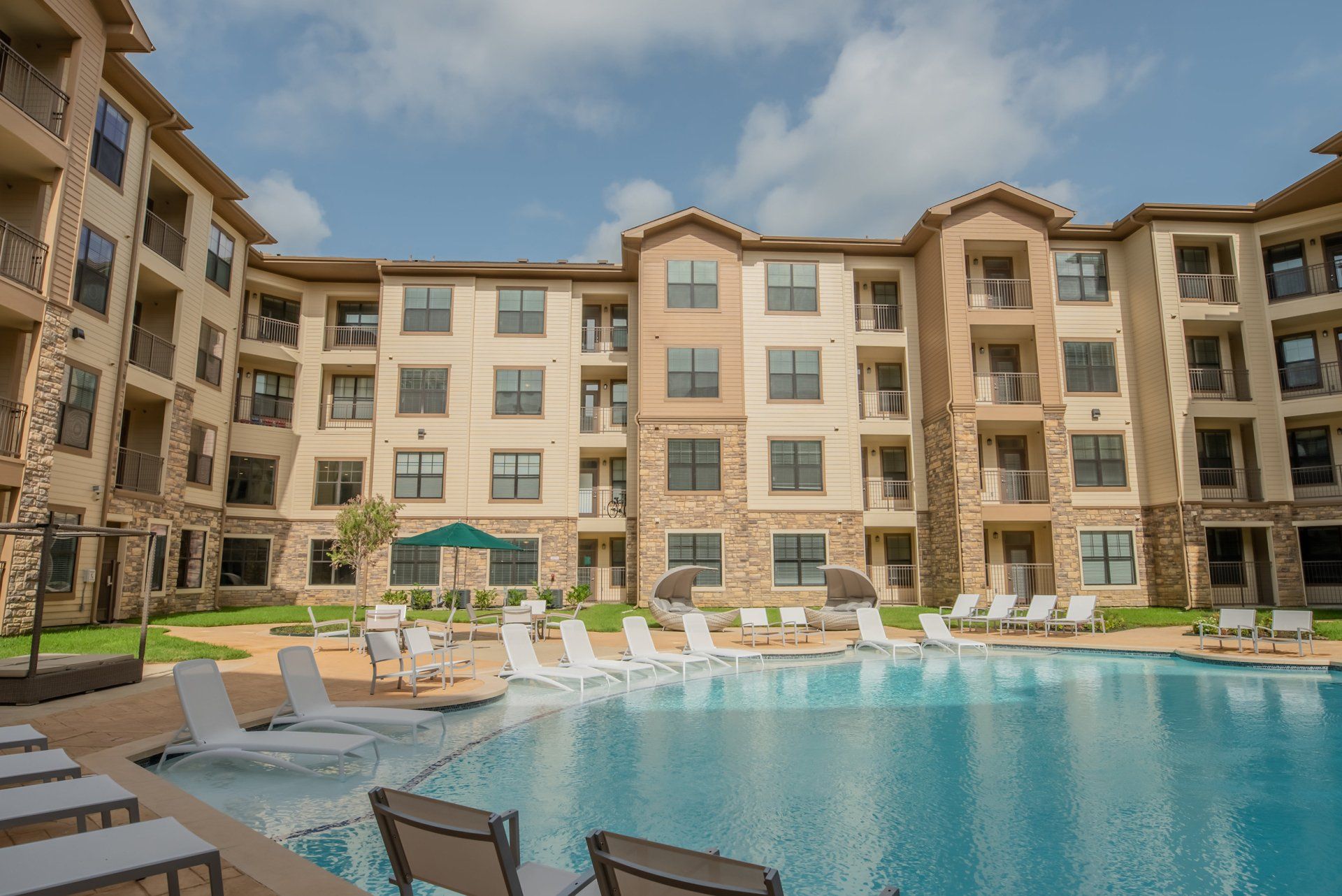 Haven at Liberty Hills | Poolside with Chairs and Apartment Building