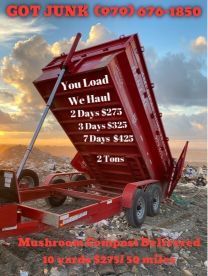 A red dumpster is sitting in a pile of trash.