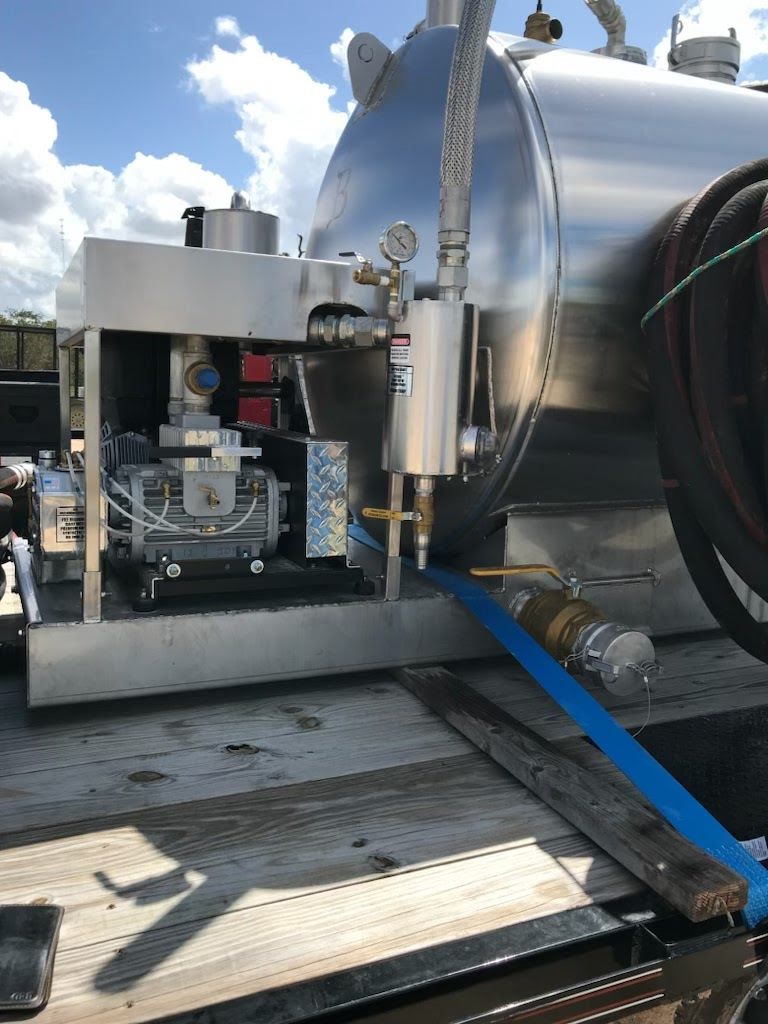 A large stainless steel tank is sitting on the back of a truck.