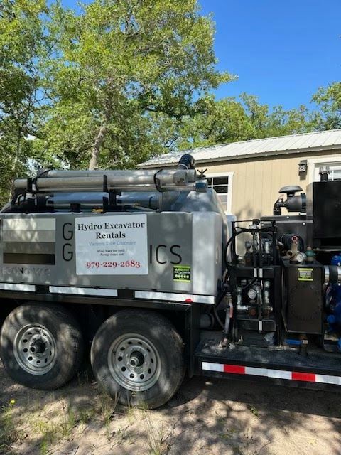 A trailer with a machine on it is parked in front of a house.