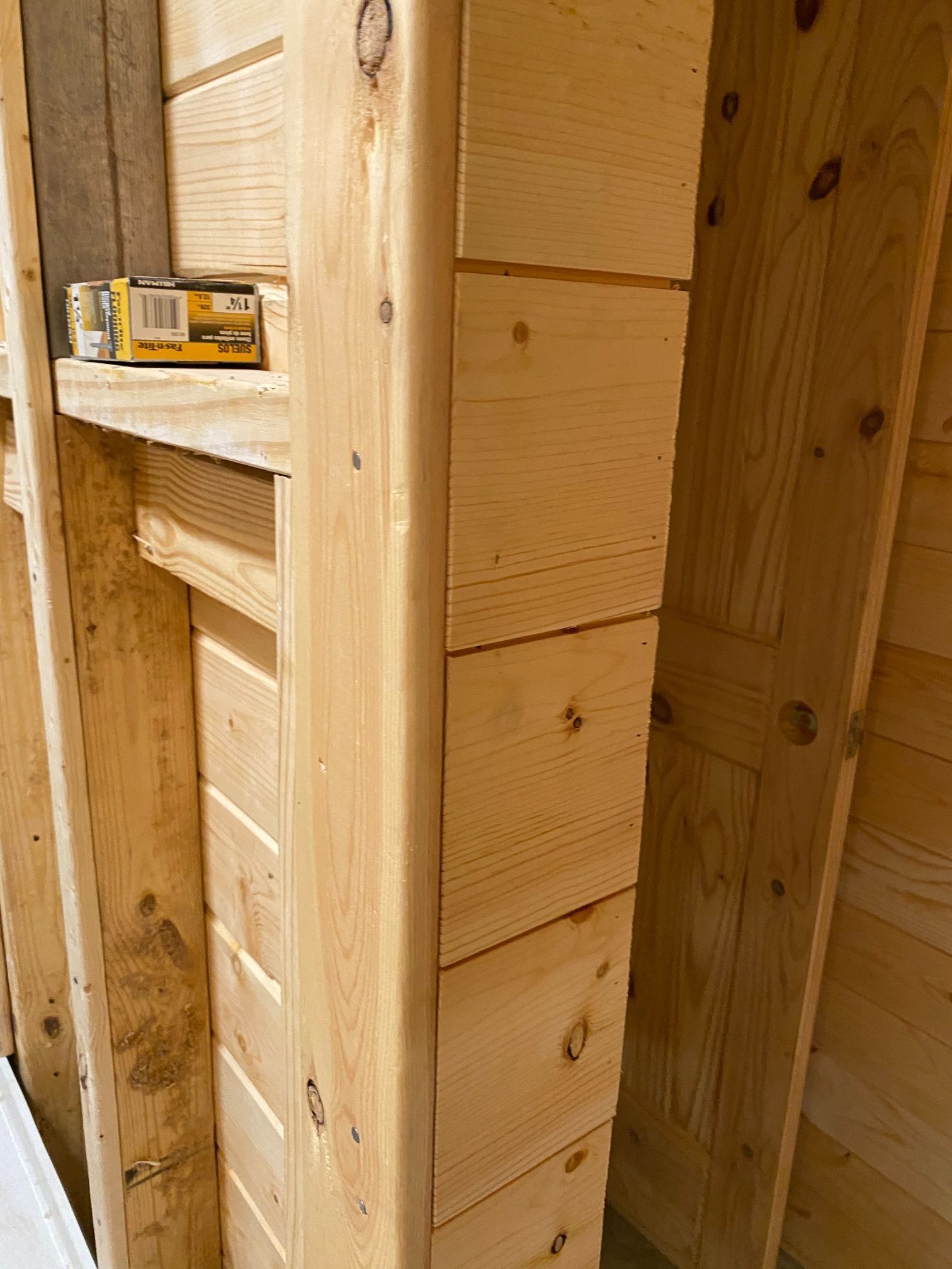 A close up of a wooden wall with a box on top of it.
