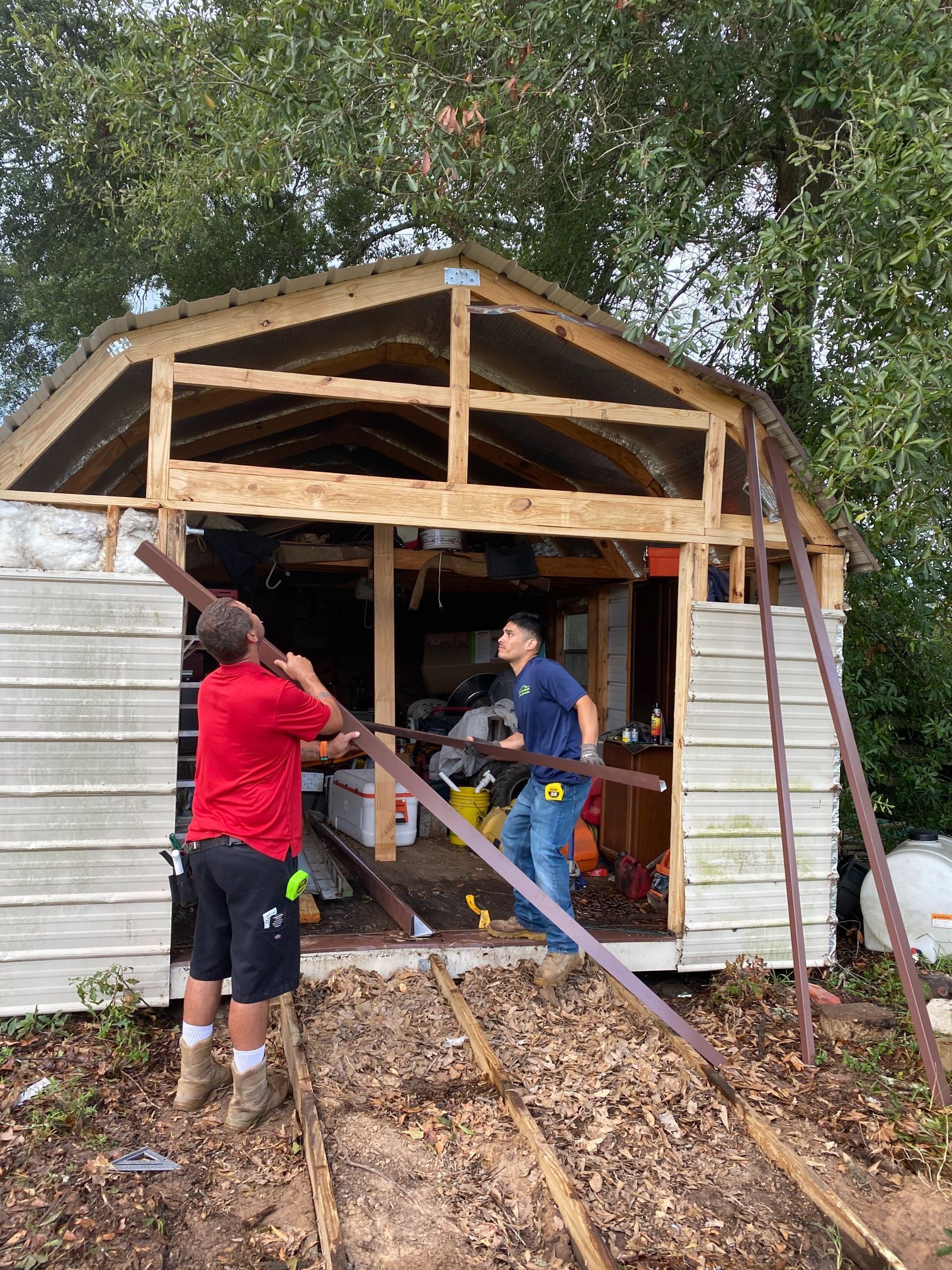 A couple of men are working on a shed.