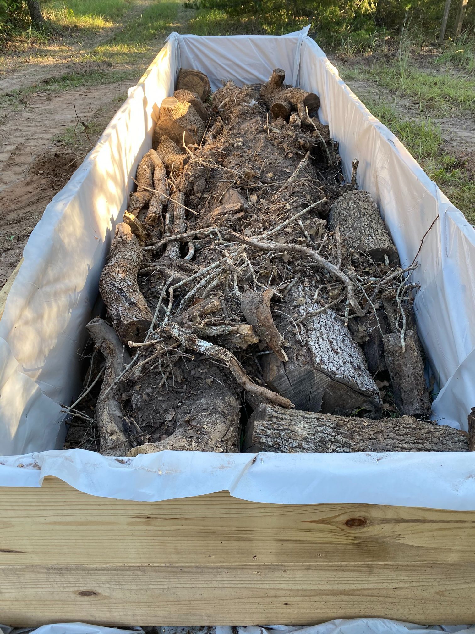 A large pile of logs is sitting in a wooden box.