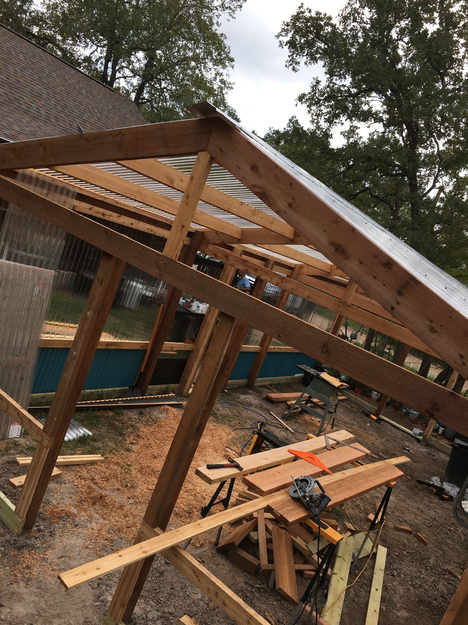 A wooden structure is being built with a metal roof.