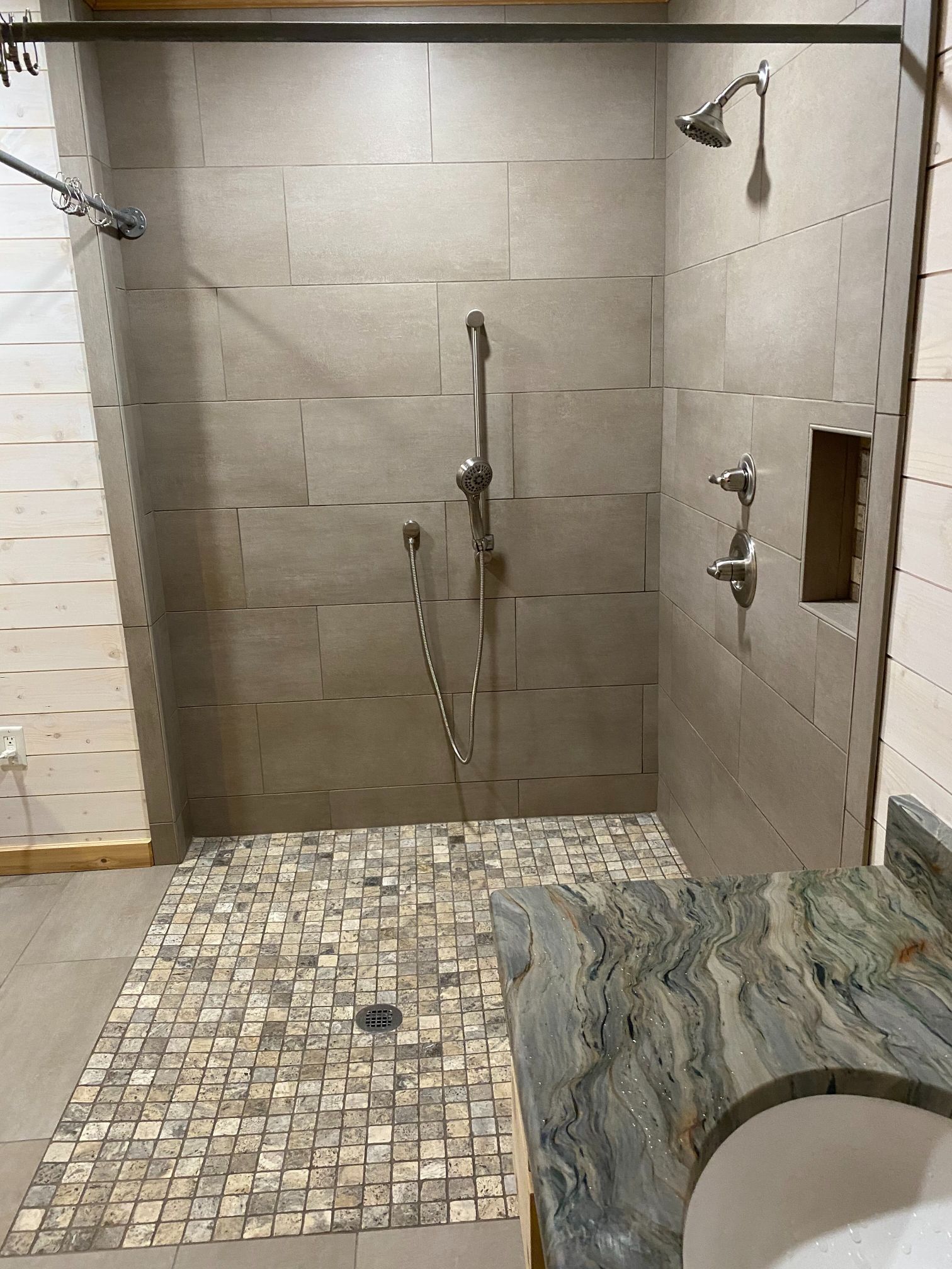 A bathroom with a walk in shower and a sink