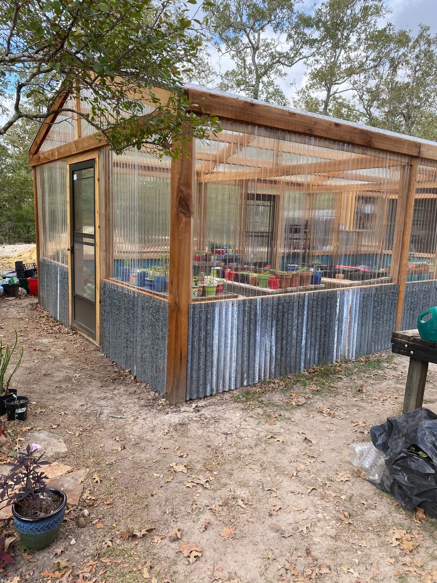 A greenhouse with a lot of potted plants inside of it.