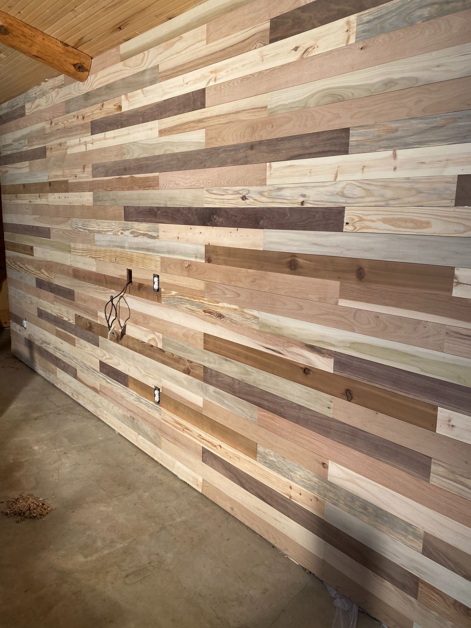 A large wooden wall in a room with a concrete floor.