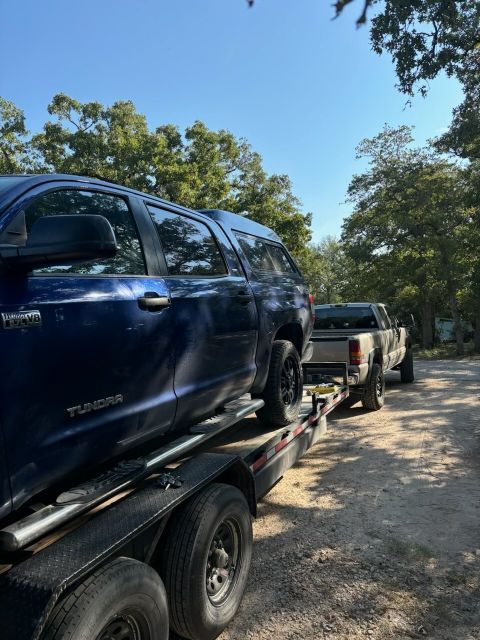 A blue tundra is being towed on a trailer
