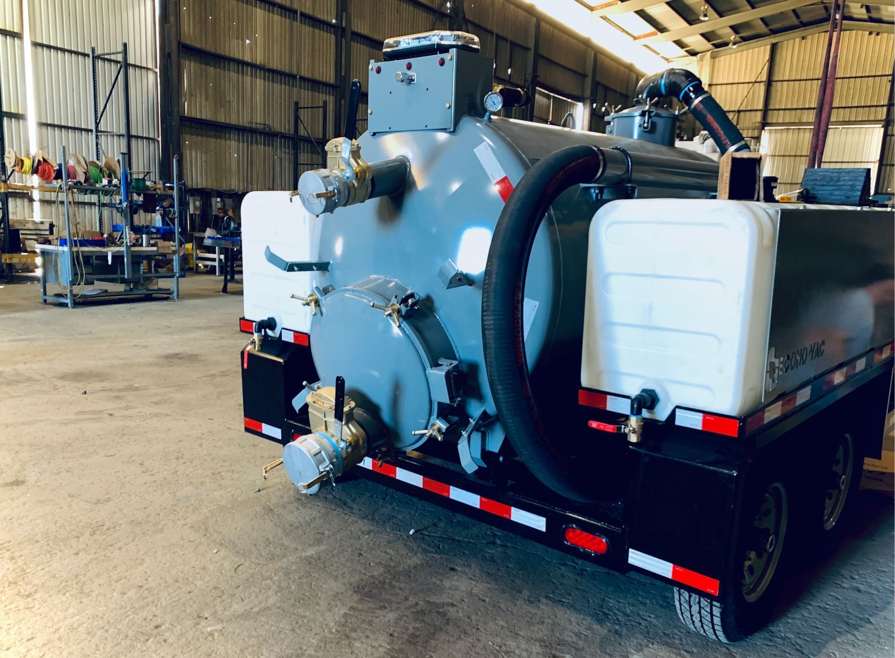 A large vacuum truck is parked in a warehouse.