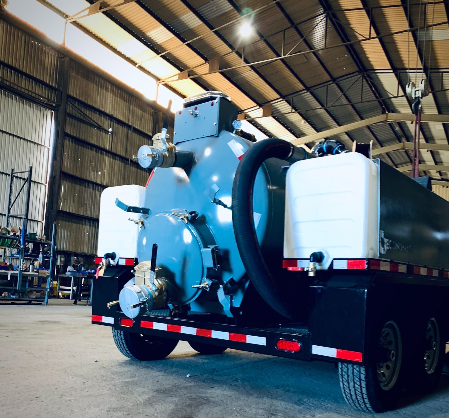 A large vacuum truck is parked in a warehouse