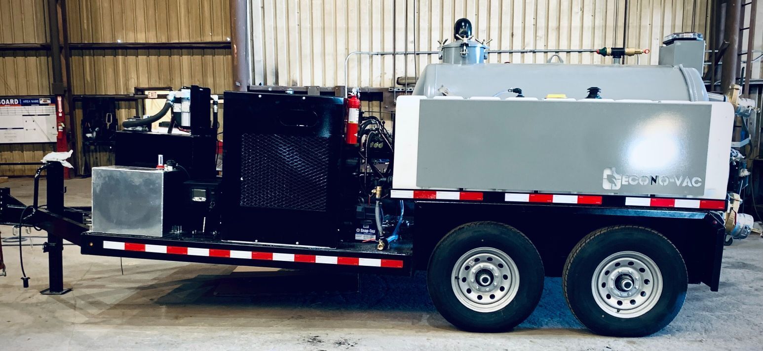A trailer with a machine on it is parked in a warehouse.