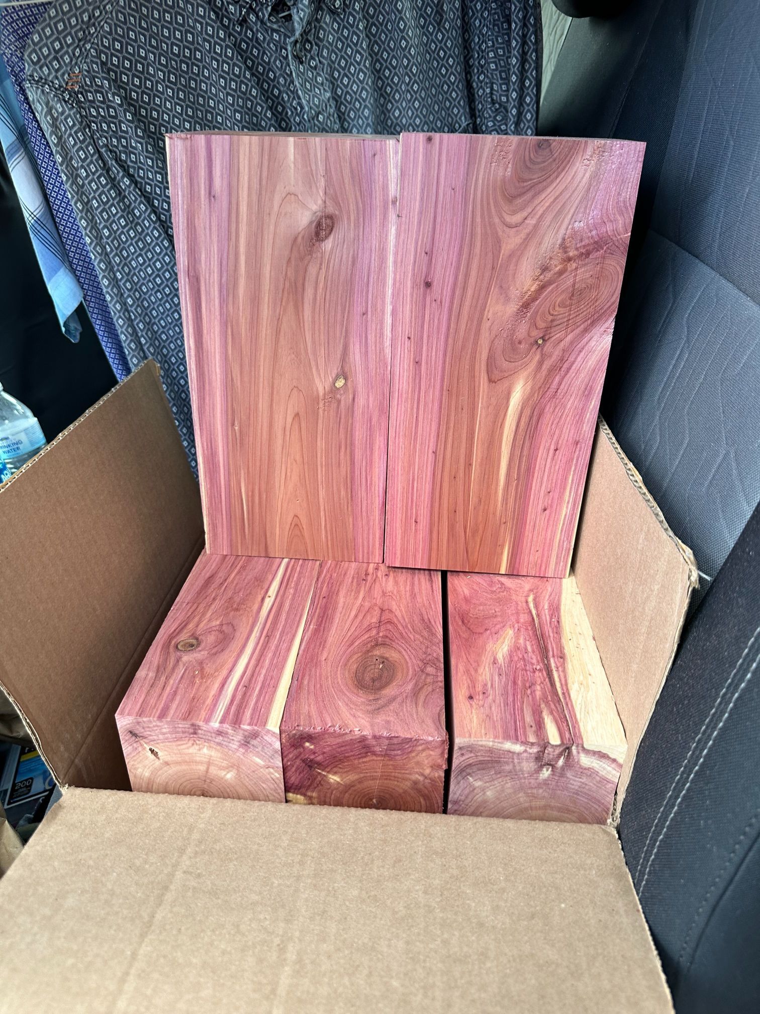 A box of cedar blocks is sitting in the back seat of a car.