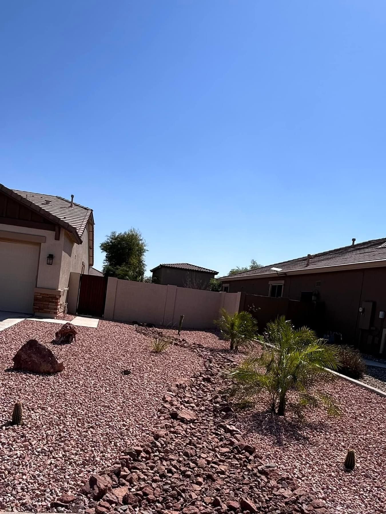 A house with a garage and a lot of rocks in front of it.