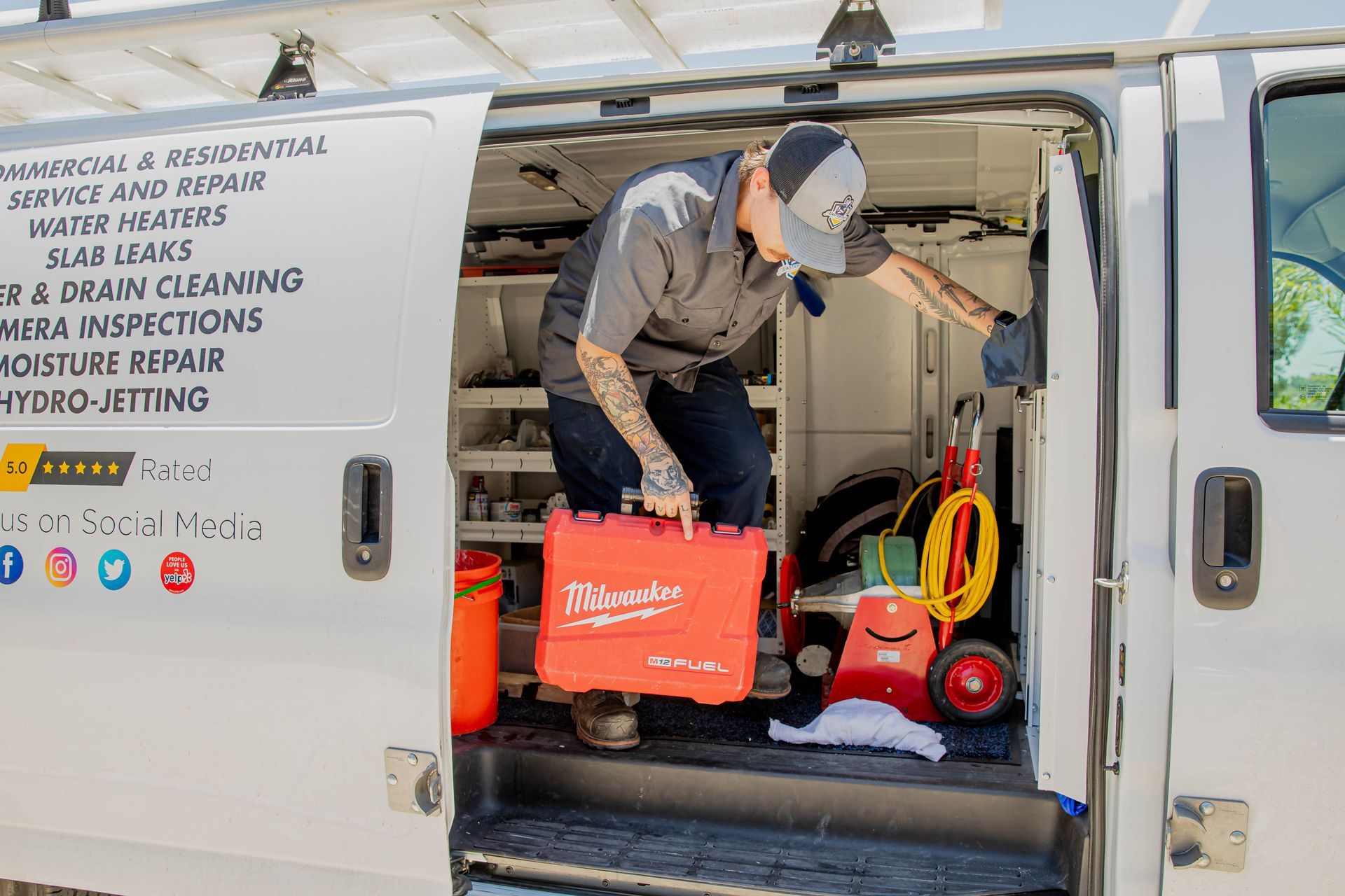 A man is loading tools into the back of a van.
