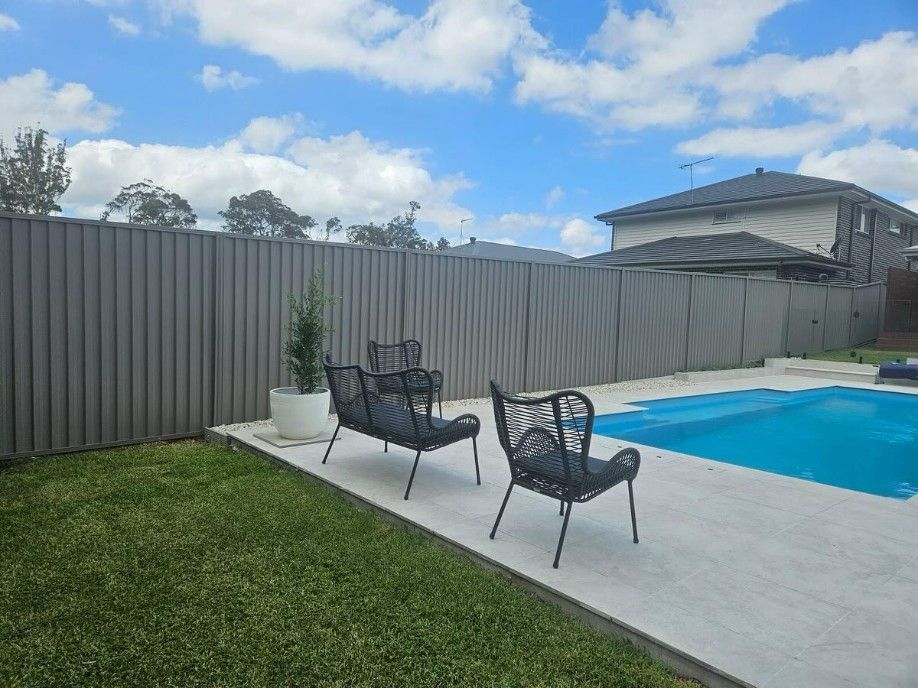 A Fence Surrounds a Swimming Pool in a Backyard — JOA - Construction & Maintenance in Appin, NSW