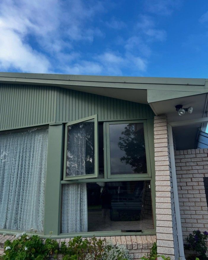 A Brick House With a Green Roof and a Large Window — JOA - Construction & Maintenance in Appin, NSW