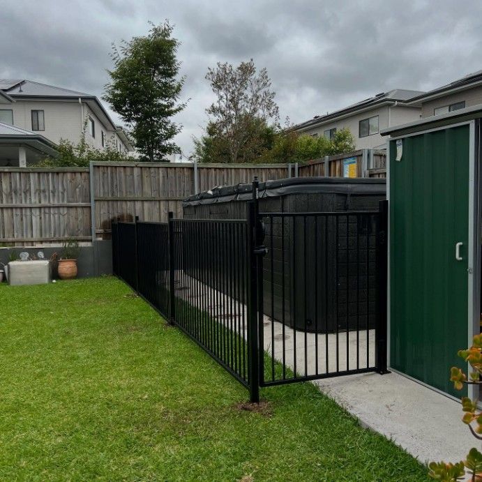 A Backyard With a Black Fence and a Green Shed — JOA - Construction & Maintenance in Appin, NSW