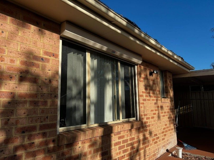A Brick House With a Large Window on the Side — JOA - Construction & Maintenance in Narellan, NSW