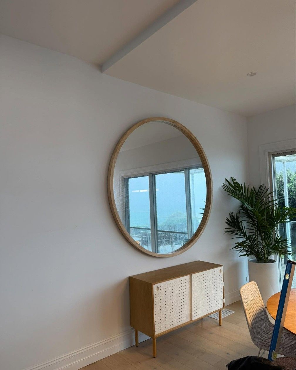 A Large Round Mirror is Hanging on a White Wall — JOA - Construction & Maintenance in Albion Park, NSW