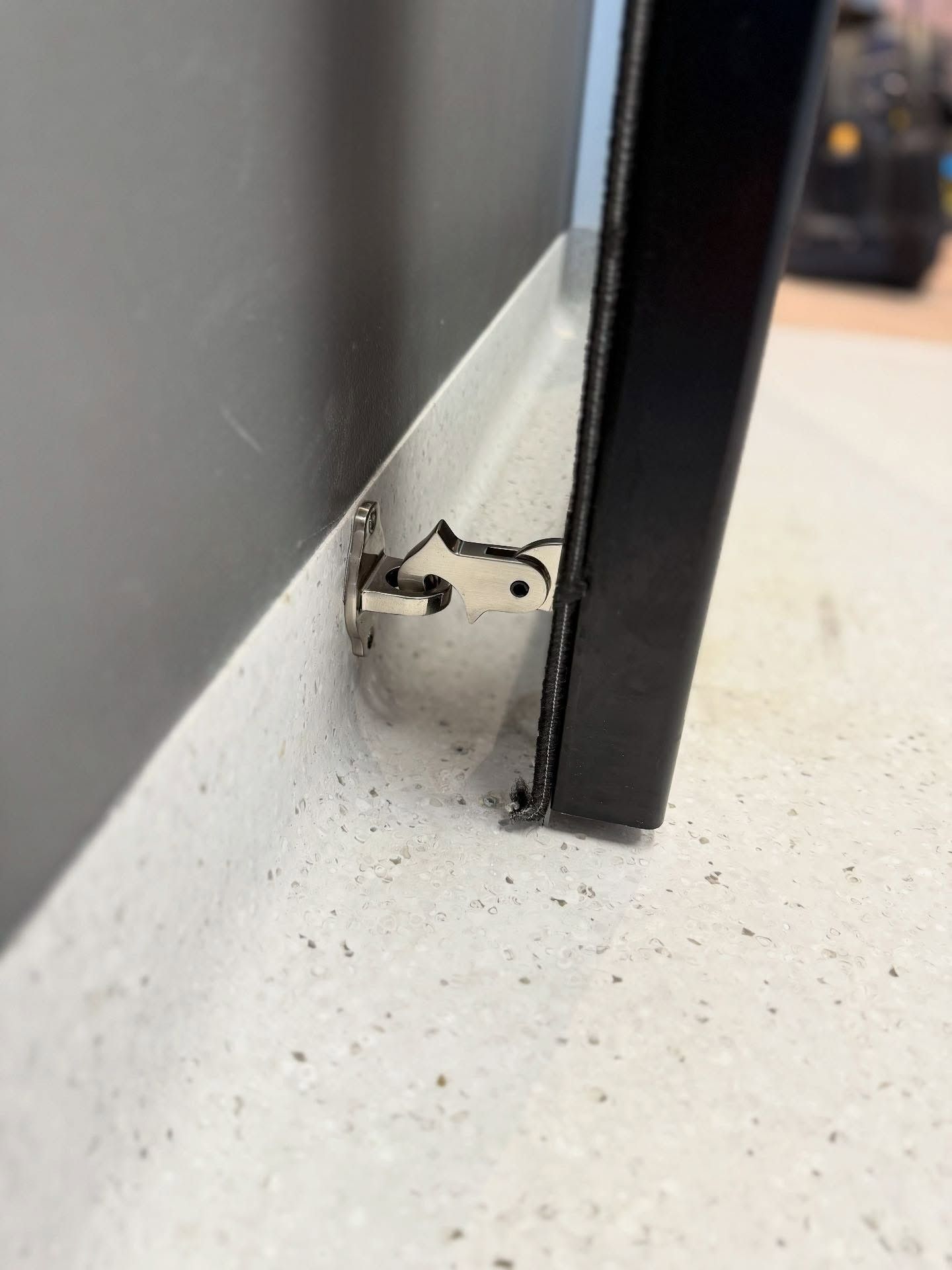 A Black Door is Sitting on a White Floor Next to a Wall — JOA - Construction & Maintenance in Wollongong, NSW