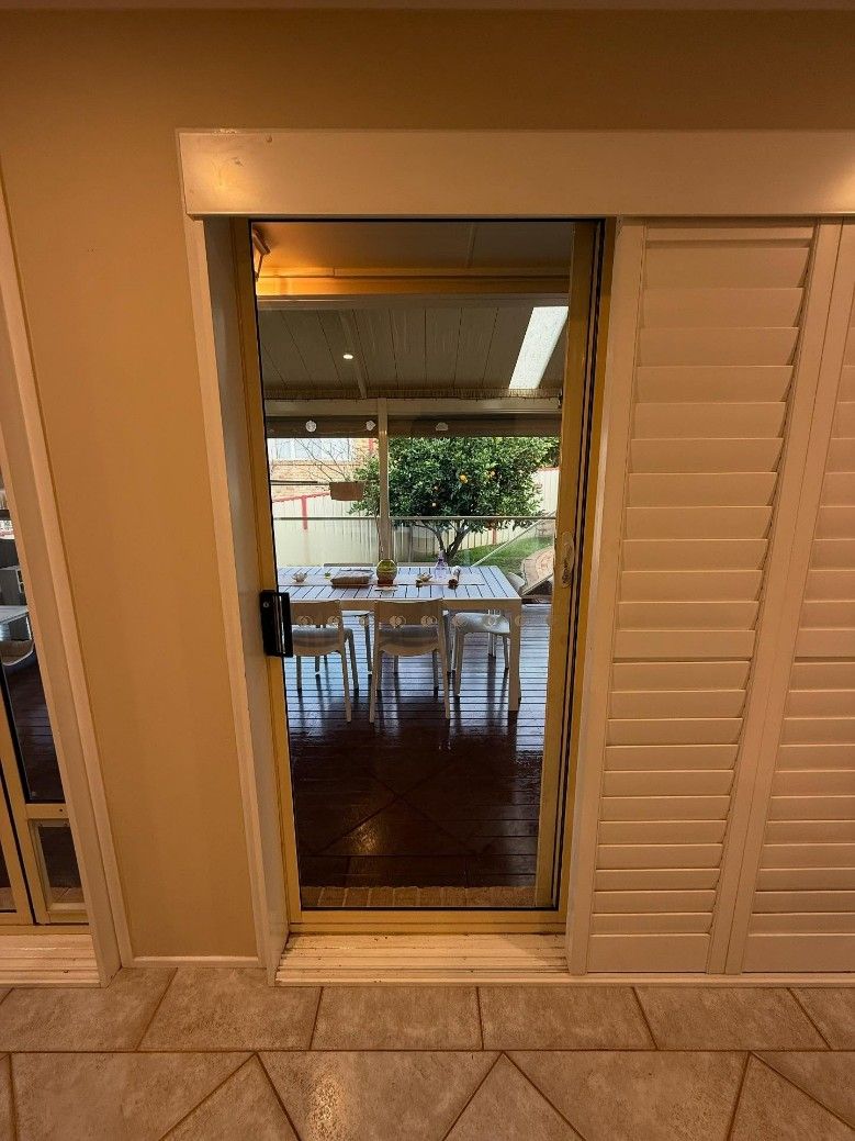 A Sliding Glass Door Leading to a Dining Room — JOA - Construction & Maintenance in Campbelltown, NSW