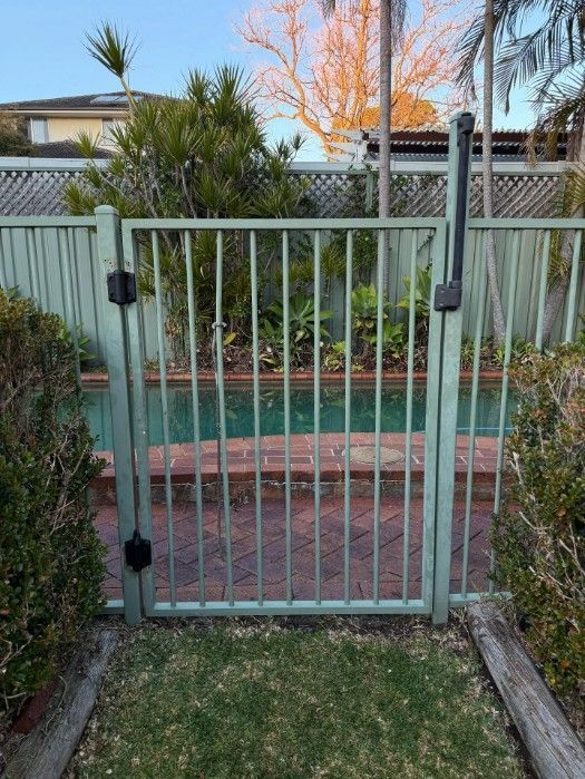 A Gate Leading to a Swimming Pool in a Backyard — JOA - Construction & Maintenance in Appin, NSW