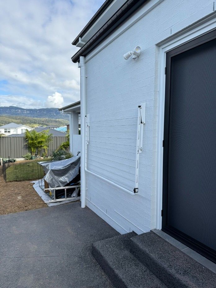 A White House With a Black Door and Stairs — JOA - Construction & Maintenance in Appin, NSW