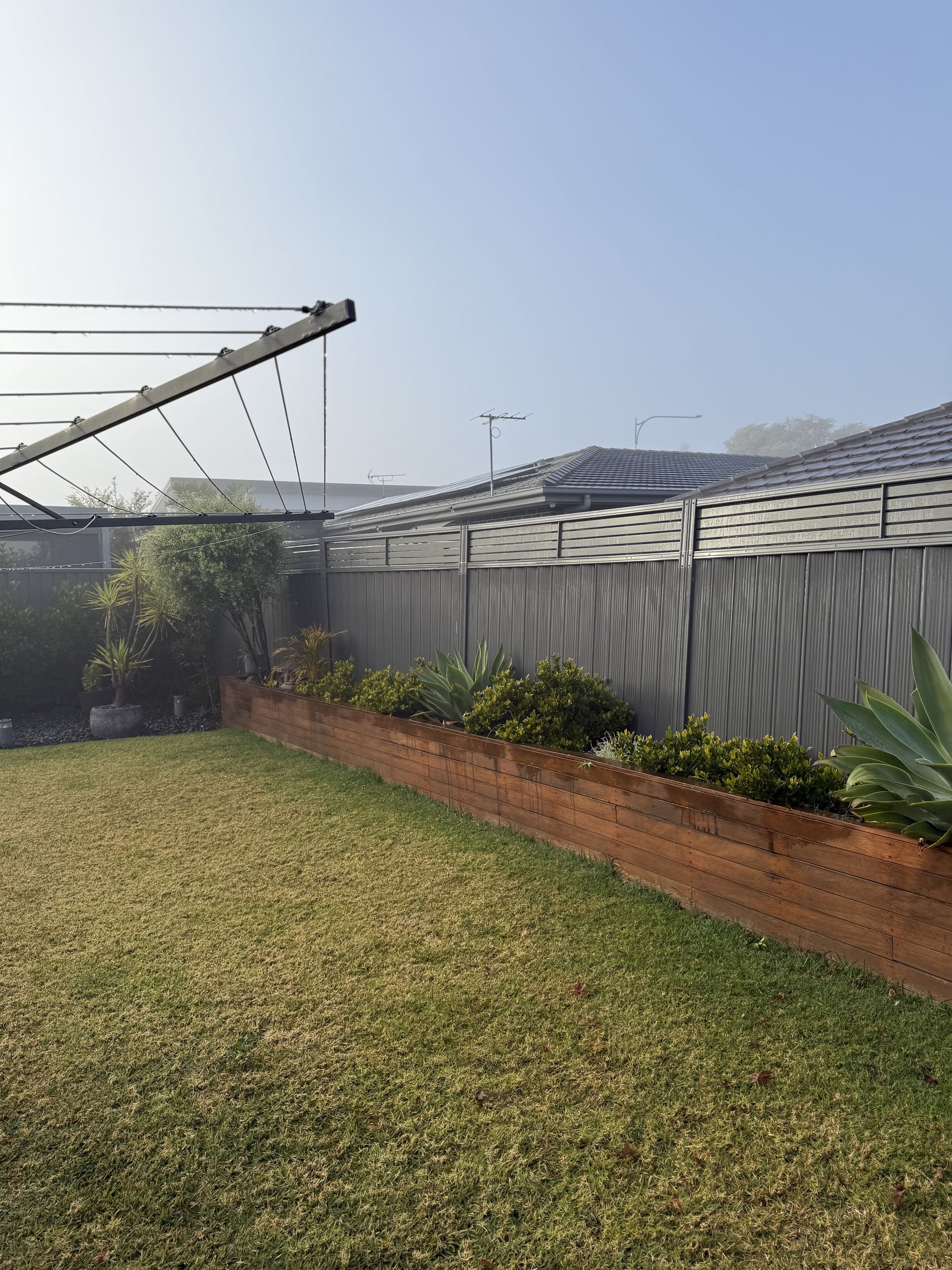 A lawn with a clothes line and a fence in the background. — JOA - Construction & Maintenance in Appin, NSW