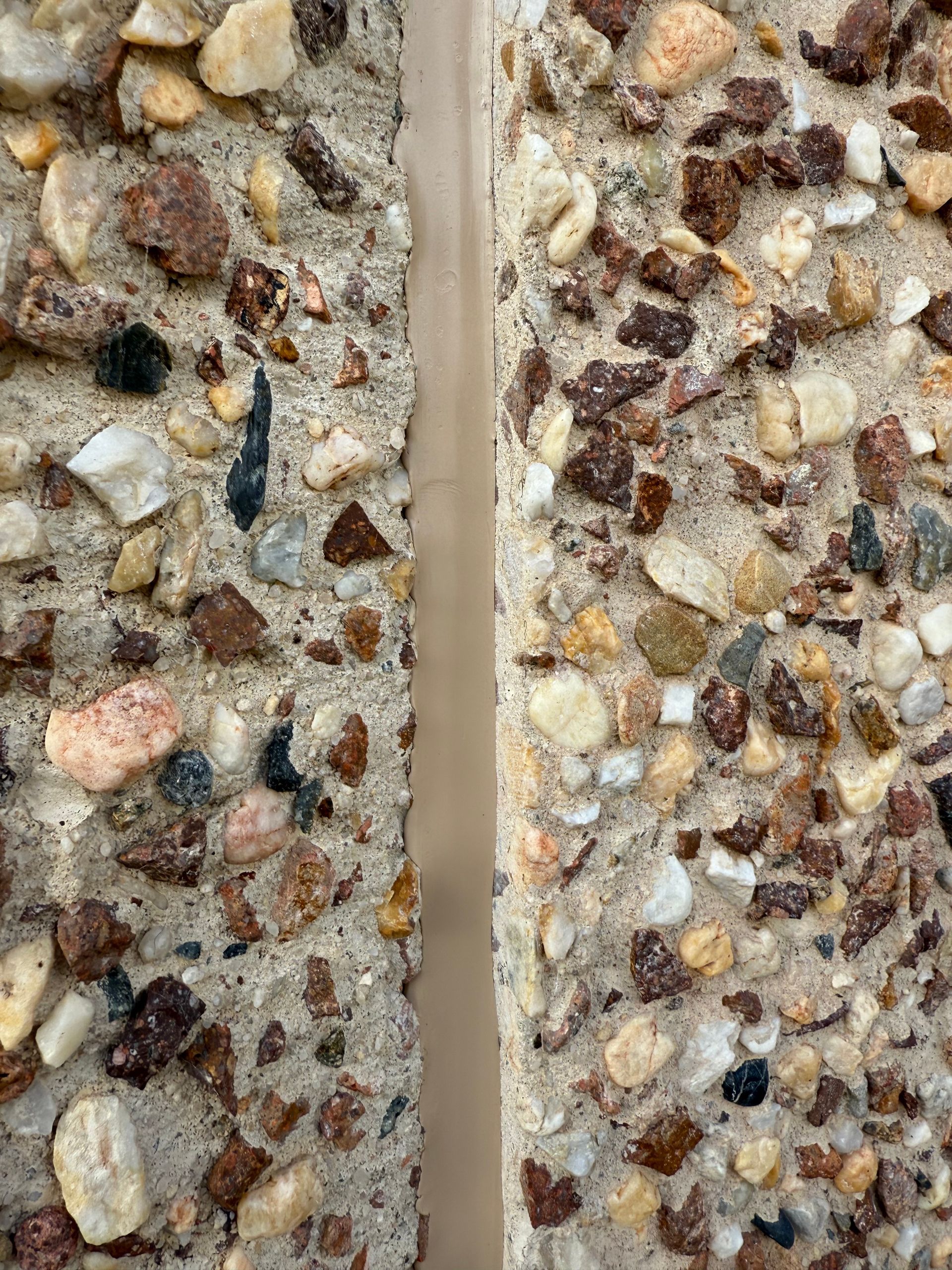 A close up of two pieces of concrete with rocks on them. — JOA - Construction & Maintenance in Appin, NSW